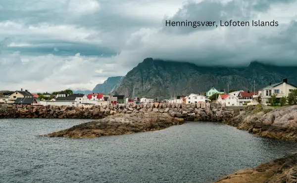 Henningsvær harbor with fishing houses and cliffs.